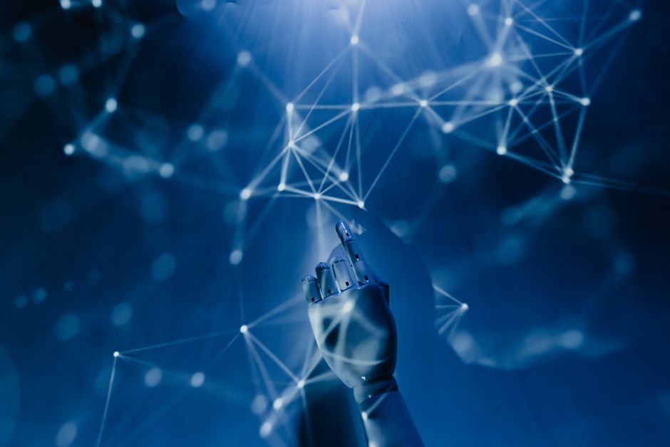 A robotic hand reaching into a digital network on a blue background, symbolizing AI technology